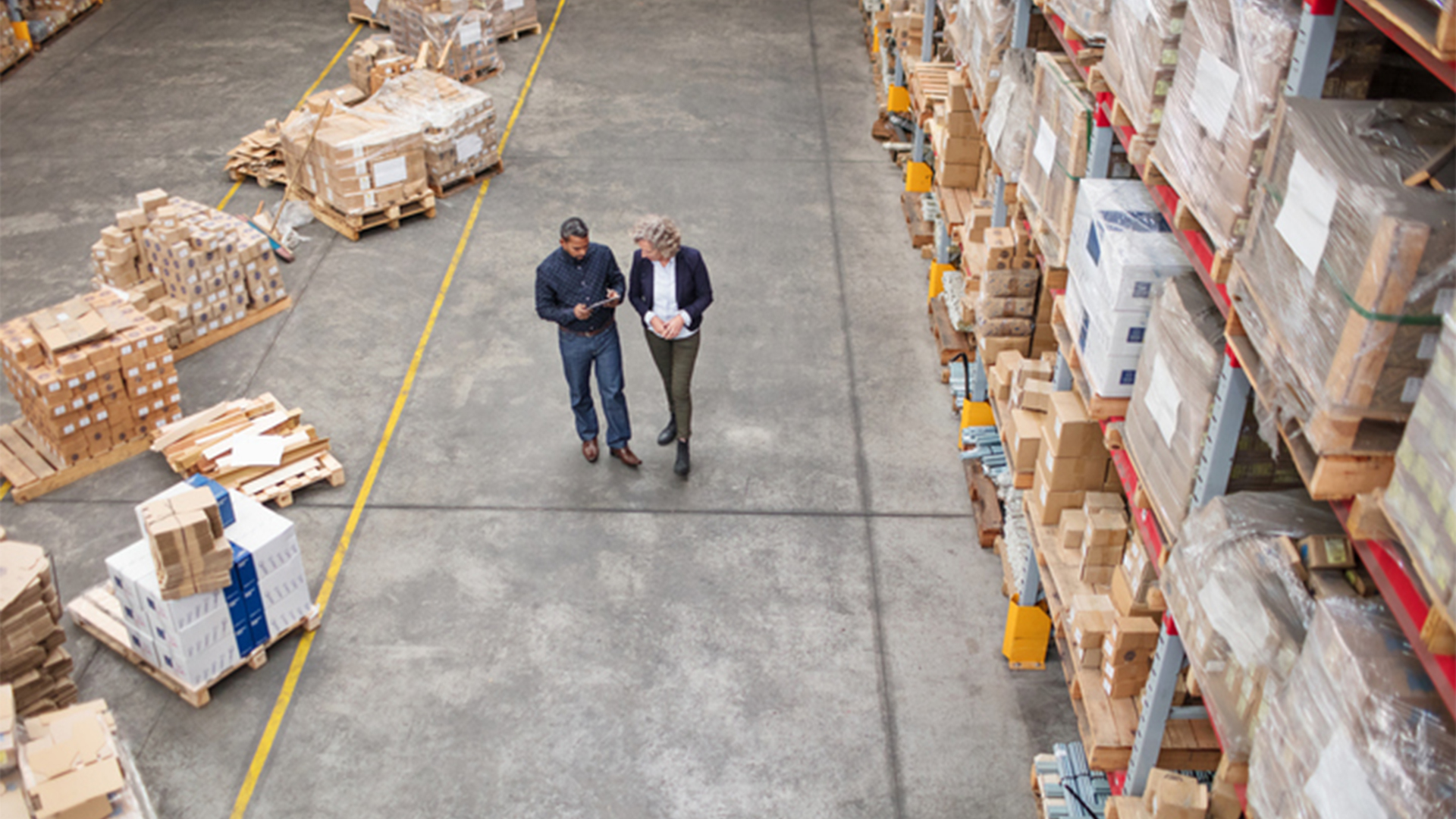 Managers walking in a warehouse looking at security cameras
