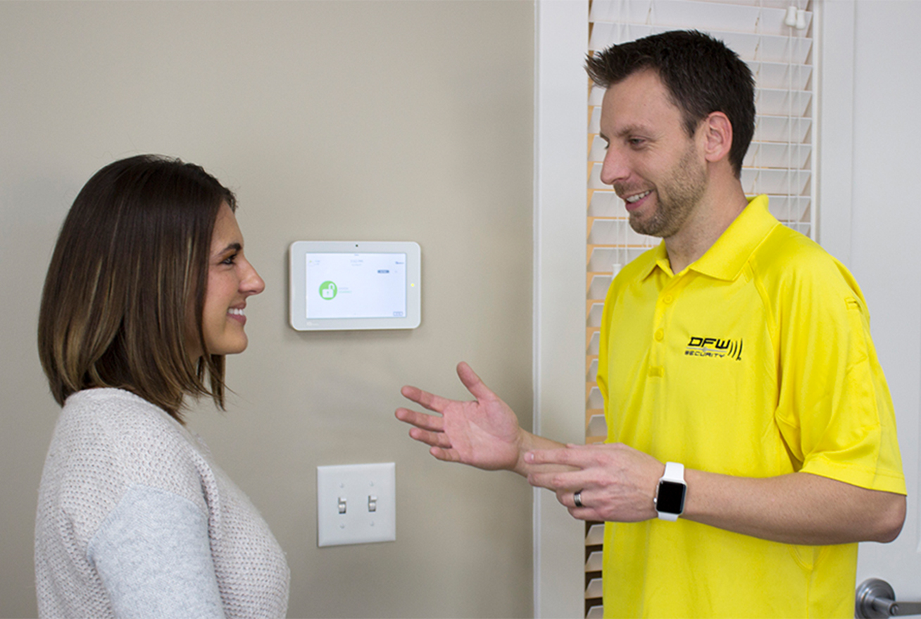 DFW Security technician showing security system to homeowner