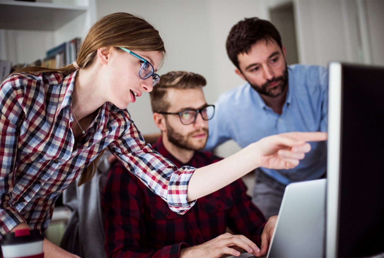 Team of 3 looking at computer analyzing reports