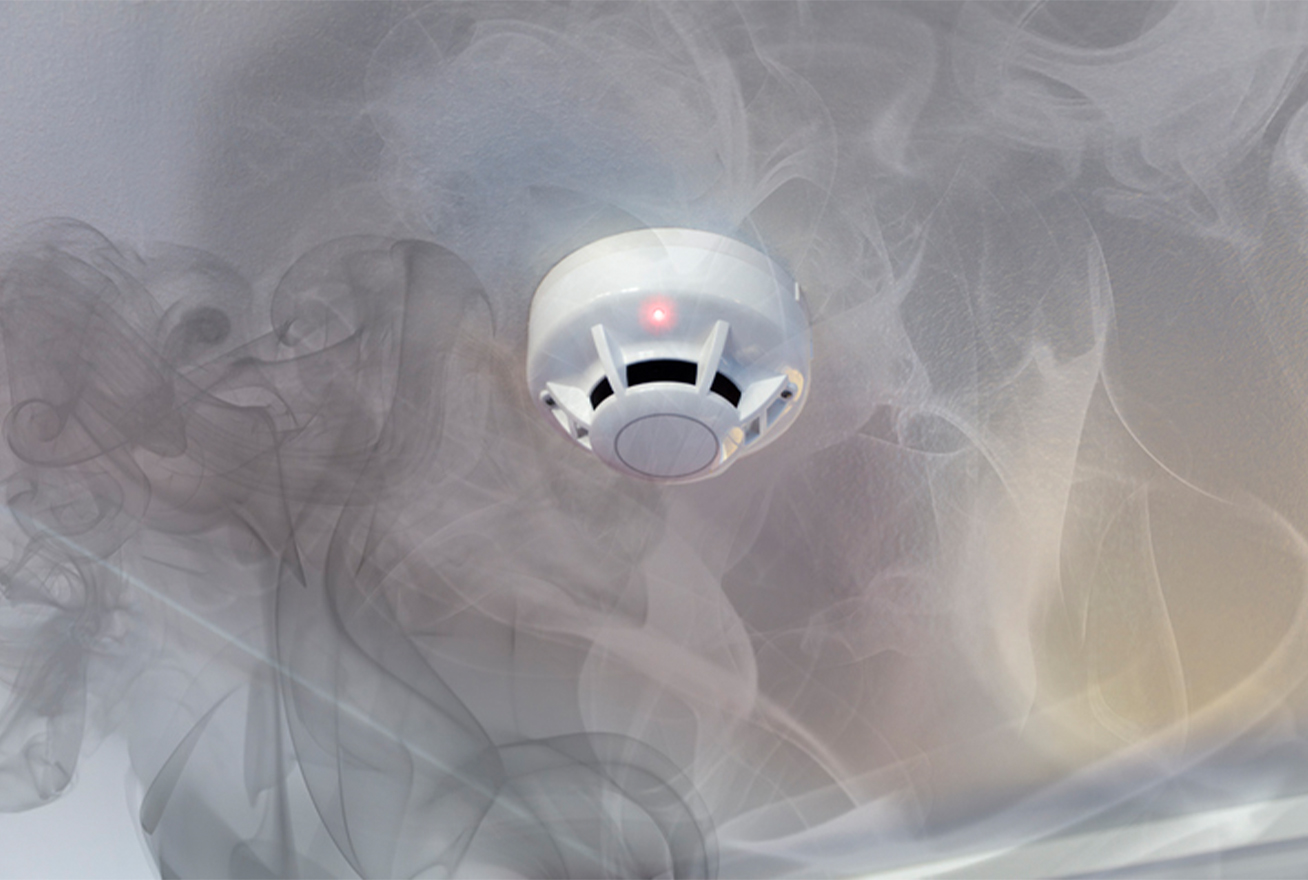 smoke detector on ceiling surrounded by smoke
