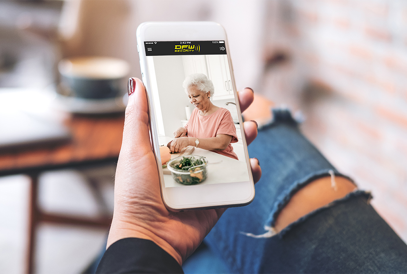 Woman looking at phone with video of older woman in kitchen