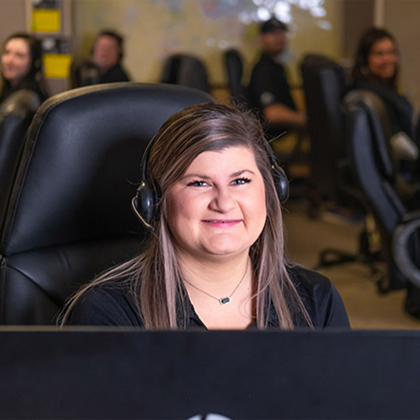 DFW Security Sales Coordinator smiling at her desk