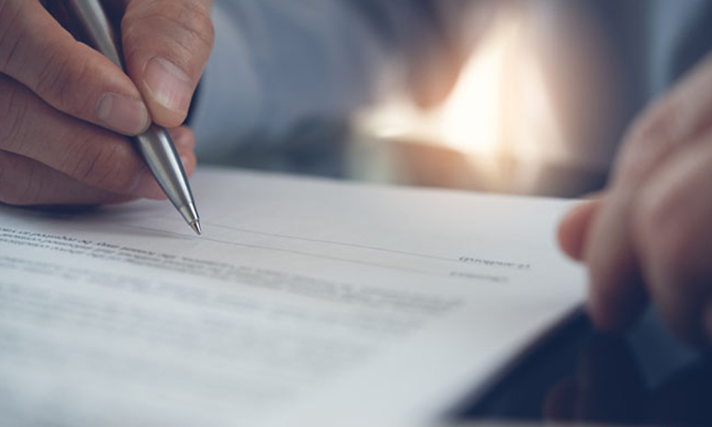 Blurred view of someone signing a contract