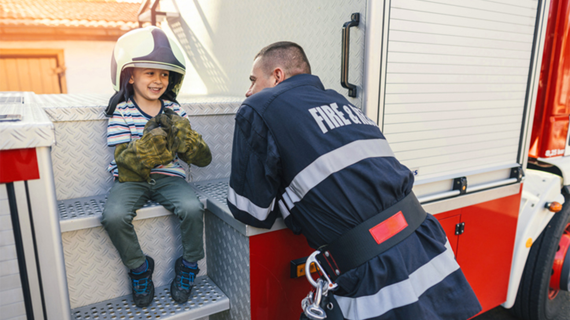 Firefighter talking with happy young child