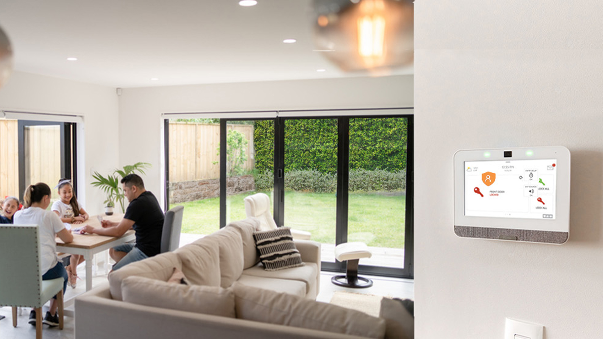 family playing games at the table with smart security system on wall