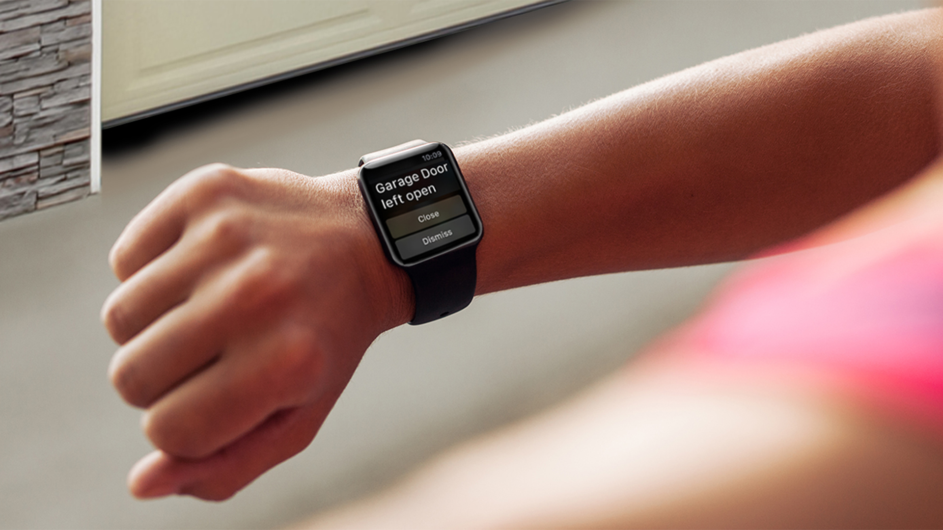 a woman looking at her smart watch with an alert showing her garage door was left open