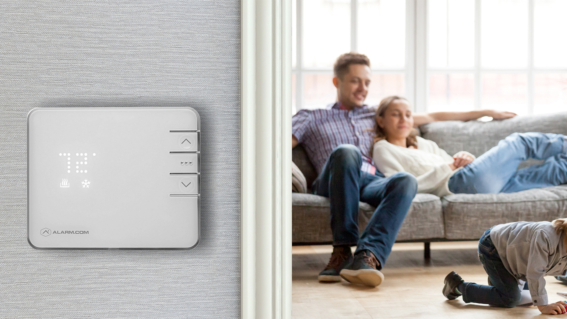 Smart thermostat on wall with family playing in the background