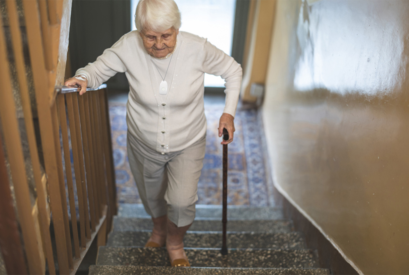 Elderly woman walking up the stairs with a cane