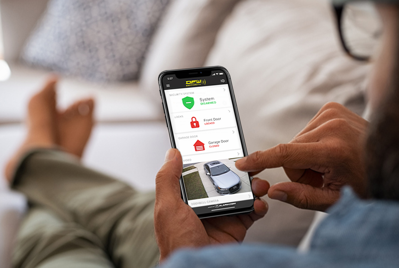 peaceful man on couch looking at DFW security app on his phone