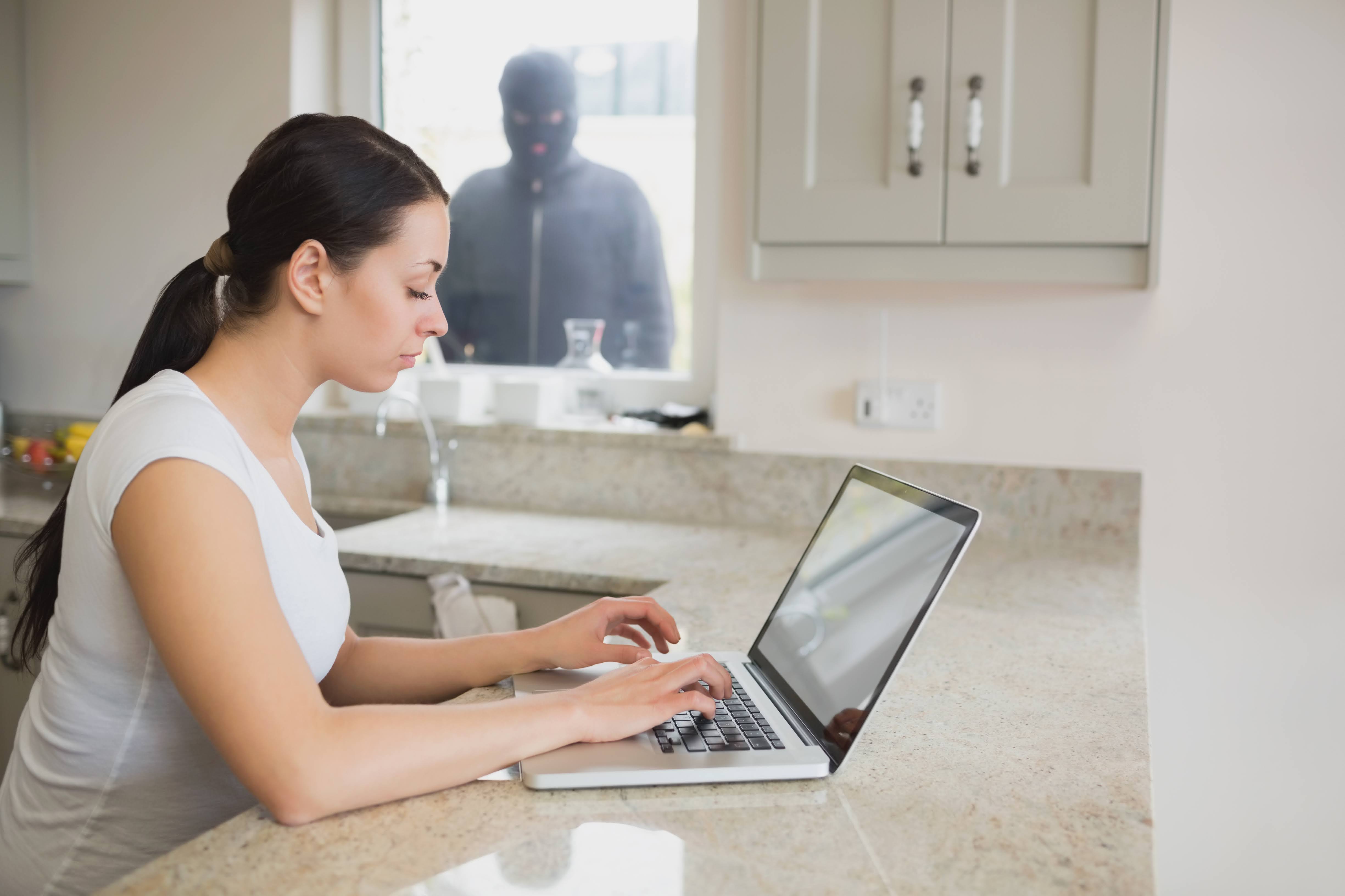 Woman working while burglar watches