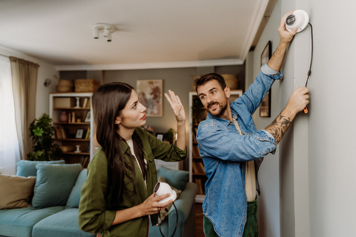 Couple do self installation of a home security camera