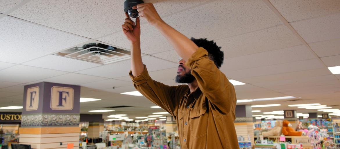 Man installing security camera on the ceiling