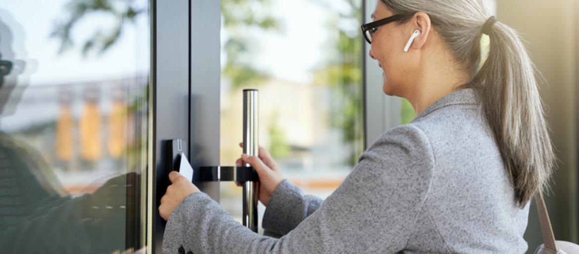 Woman opening business door using badge reader