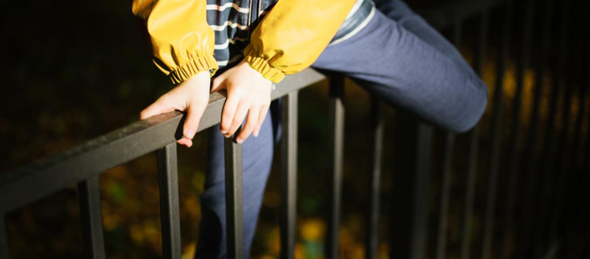 Person climbing a fence into back yard