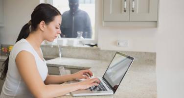 Woman working while burglar watches