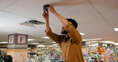 Man installing security camera on the ceiling